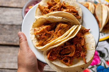 Mexican cochinita pibil tacos with habanero sauce on wooden background