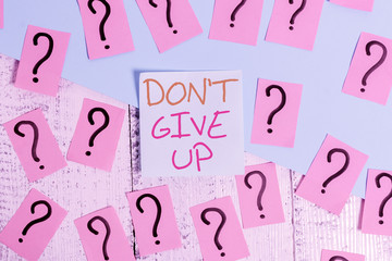 Word writing text Don T Give Up. Business photo showcasing Determined Persevering Continue to Believe in Yourself Scribbled and crumbling papers with thick cardboard above wooden table