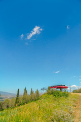 Mountain with chairlift terminal against blue summer sky in Park City ski resort