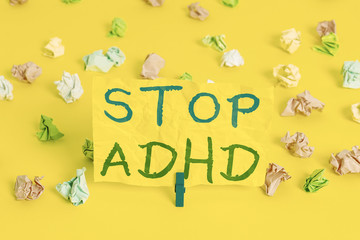 Handwriting text writing Stop Adhd. Conceptual photo Put at end the mental health disorder of children Hyperactive Colored crumpled papers empty reminder white floor background clothespin
