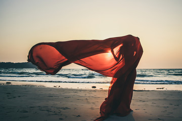 Creature in a red floaty robe standing on the beach sunset golden hour silhouette Ngapali beach...