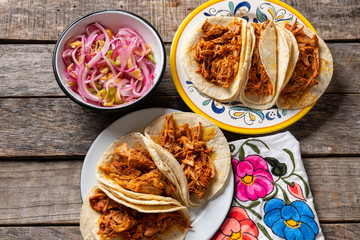 Mexican cochinita pibil tacos with habanero sauce on wooden background