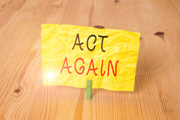 Conceptual hand writing showing Act Again. Concept meaning do something for a particular purpose Take action on something Wooden floor background green clothespin groove slot office