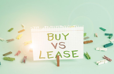 Word writing text Buy Vs Lease. Business photo showcasing Own something versus borrow it Advantages Disadvantages Colored clothespin rectangle square shaped paper light blue background