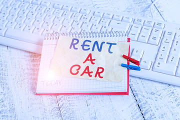 Conceptual hand writing showing Rent A Car. Concept meaning paying for temporary vehicle usage from one day to months notebook reminder clothespin with pinned sheet light wooden