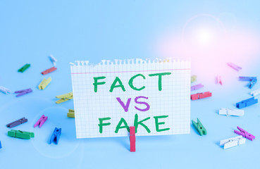 Word writing text Fact Vs Fake. Business photo showcasing Rivalry or products or information originaly made or imitation Colored clothespin rectangle square shaped paper light blue background