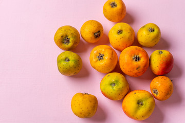 Mexican tejocote fruit on pink background