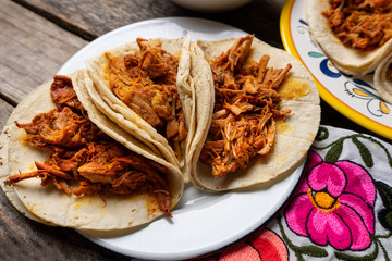 Mexican cochinita pibil tacos with habanero sauce on wooden background
