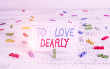 Handwriting text writing To Love Dearly. Conceptual photo Love someone very much in the more humble way and aimlessly Green clothespin white wood background colored paper reminder office supply