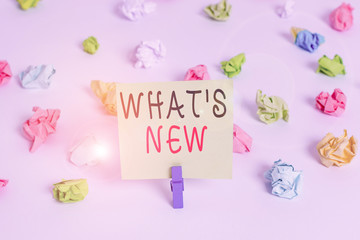 Fototapeta na wymiar Word writing text What S Is New. Business photo showcasing Asking about latest Updates Trends and Happening News Colored crumpled papers empty reminder white floor background clothespin