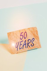 Word writing text 50 Years. Business photo showcasing Honoring Ruby Jubilee Commemorating a special day Semicentennial Paper placed tilted above buffer wire on soft pastel multi colours backdrop