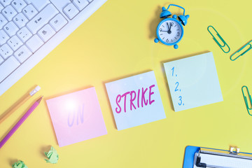 Writing note showing On Strike. Business concept for refuse to continue working because of an argument with an employer Flat lay above copy space on the white crumpled paper