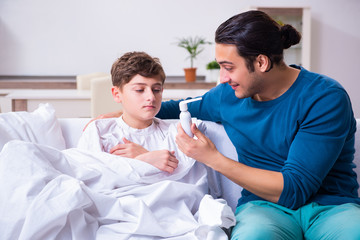 Fototapeta premium Young father caring for sick son