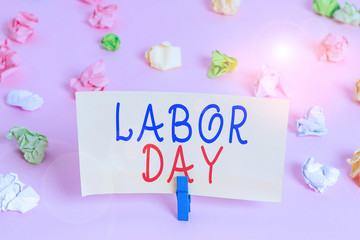 Word writing text Labor Day. Business photo showcasing an annual holiday to celebrate the achievements of workers Colored crumpled papers empty reminder pink floor background clothespin