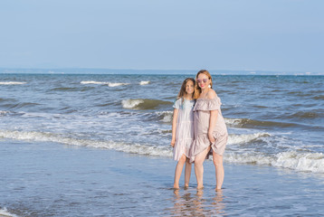 Fototapeta na wymiar Happy mom and daughter spend time together at the seaside, family concept.