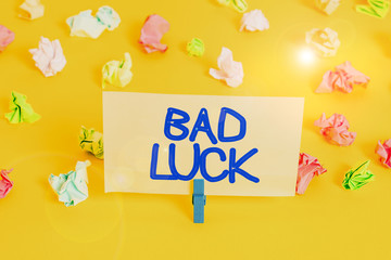 Handwriting text writing Bad Luck. Conceptual photo an unfortunate state resulting from unfavorable outcomes Mischance Colored crumpled papers empty reminder white floor background clothespin
