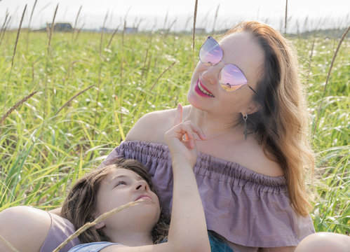 Happy mom and daughter spend time together on the meadow, Meditate, family concept.