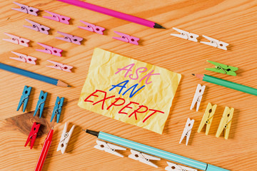 Text sign showing Ask An Expert. Business photo showcasing Superior Reliable Ace Virtuoso Curapp storeity Authority Geek Colored clothespin papers empty reminder wooden floor background office