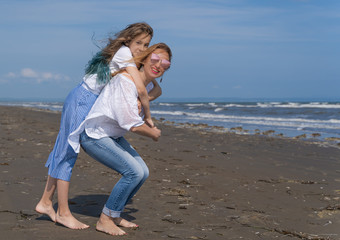 Happy mom and daughter spend time together at the seaside, family concept.