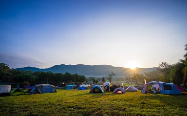 Gordijnen Camping and tent in nature park with sunrise behind the mountain © domonite