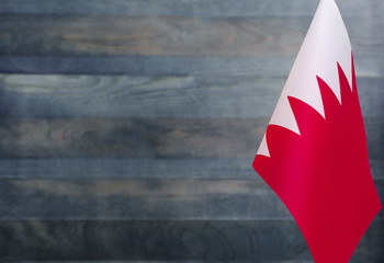 Fragment of the flag of the Kingdom of Bahrain in the foreground blurred light background copy space