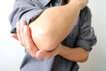 Men use their hands to hold their elbows and He had pain at the elbows.. Painful Health and medical concepts