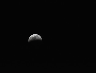 A partial lunar eclipse looms in the dark sky.