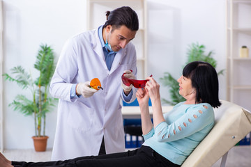 Fototapeta premium Old woman visiting young doctor dentist