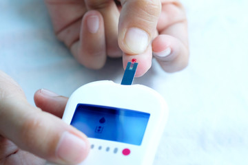 hand of people check diabetes and high blood glucose monitor with digital pressure gauge. Healthcare and Medical concept