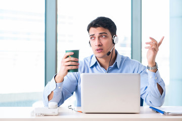 Male call-center operator in business concept