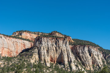 Zion National Park low angle landscape of tree-studded multi-colored stone hills at Checkerboard Mesa