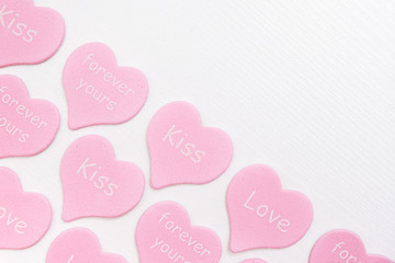 Border pink hearts with text LOVE, KISS, FOREVER YOURS on white background with copy space. Valentines day concept. Gift for lover, love confession. Top view Flat lay