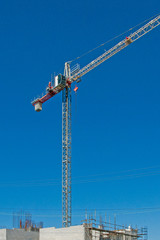 A working Construction Sky Crane on a new high rise multistory building site with blue sky background. Australia.