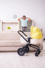 Young man looking after baby in pram