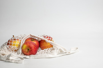 Eco-friendly Fresh Red apple in Natural Reusable Cotton Mesh Bag. Zero waste concept