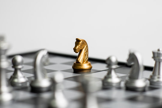 One gold chess pieces staying against full set of chess pieces on white background. Concept leader & success, strategy, business victory or decision