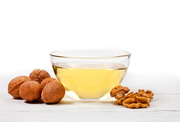 Pile walnuts heap and walnuts oil in glass bowl isolated on a white background.