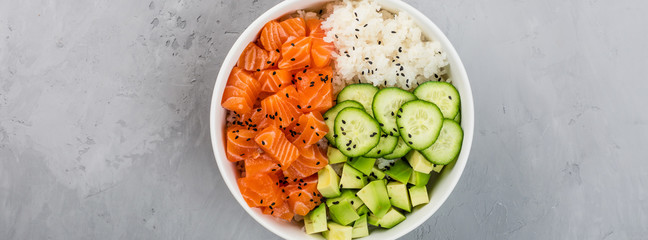 Hawaiian salmon bowl with cucumbers, avocado, sesame seeds and rice. Top view, overhead, flat lay, mock up, template. Healthy food concept