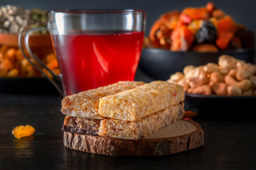Bars of sports nutrition from nuts, seeds and chocolate paste - vegetable natural protein on the background of a drink from a mix of dried fruits. Close-up