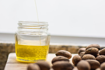 Gourmet walnut oil jar and nuts on a wooden table
