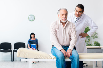 Obraz premium Old couple visiting young male doctor