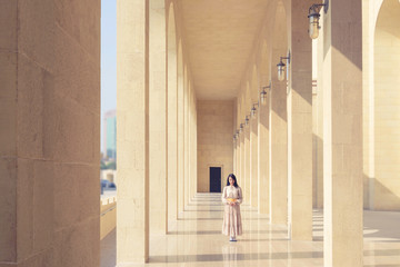 Asian traveller woman with long dress standing on perspective walkway building with morning...