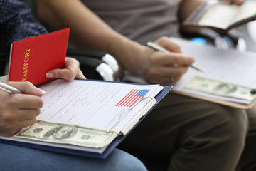 Male hand with green card USA form against airport