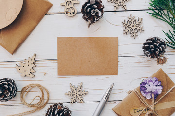 Top view of empty christmas card on wooden table with xmas decoration.