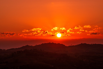 The sunset at the mountain peak in the evening has clouds with beautiful rays.