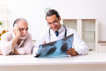 Obraz premium Young male doctor visiting old patient at home