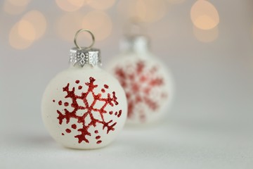 White christmas balls with red snowflakes on a  background with yellow bokeh.Christmas and New Year winter festive background