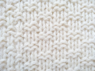 Background of wool yarn for yarn frame. White knitting yarn for handicrafts background. Knitted clothes from wool yarn.
