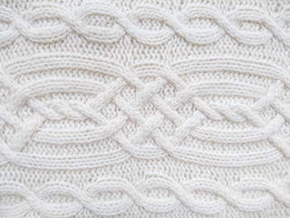 Background of wool yarn for yarn frame. White knitting yarn for handicrafts background. Knitted clothes from wool yarn.