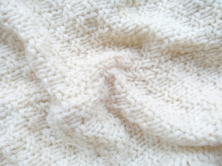 Background of wool yarn for yarn frame. White knitting yarn for handicrafts background. Knitted clothes from wool yarn.